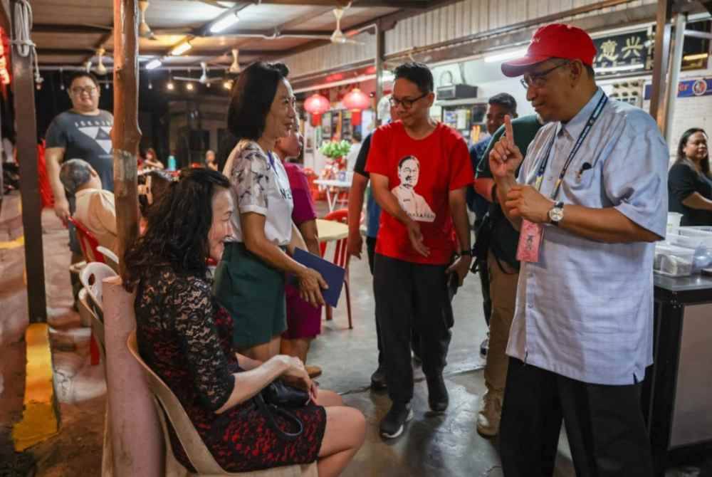 Calon PH, Dr Joohari Ariffin (kanan) beramah mesra pengundi Cina di Lai Lai Seafood Kampung Baru Wellesley sempena kempen PRK N.20 Sungai Bakap pada Khamis. Foto Bernama