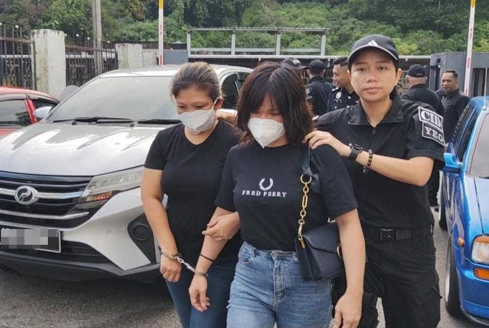 Miss Laor Mikarat (tengah) ketika dibawa ke mahkamah pada Khamis.