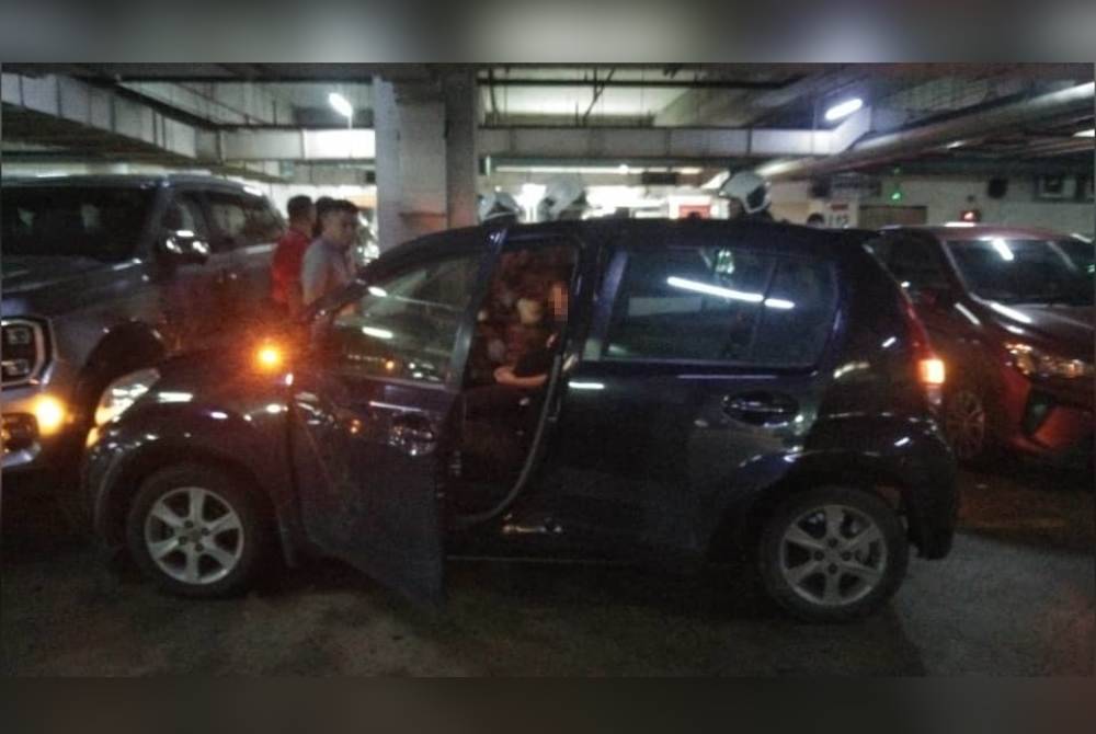 Pasukan bomba bertindak memecahkan cermin kereta bagi mengeluarkan mangsa yang tidak sedarkan diri dalam kenderaannya di kawasan parkir sebuah pasar raya di Jalan Lintas, Kota Kinabalu.