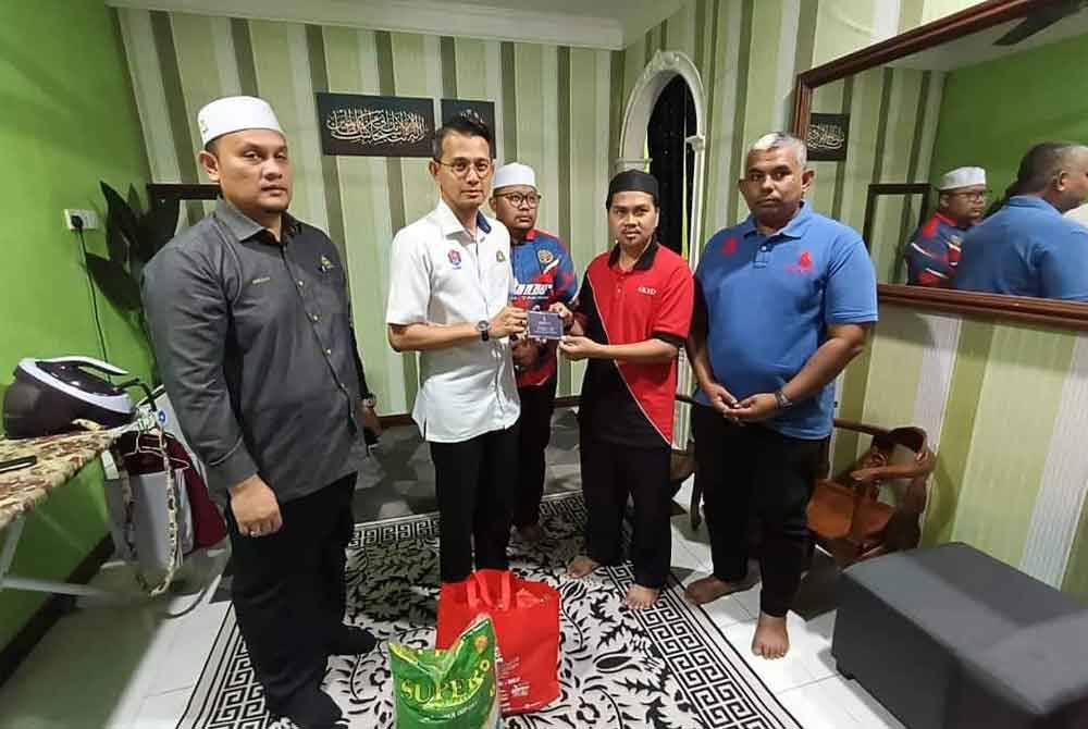 Abdul Halid (dua dari kanan) menerima kunjungan Mohd Fared dirumahnya di Tongkang Pechah pada Khamis.