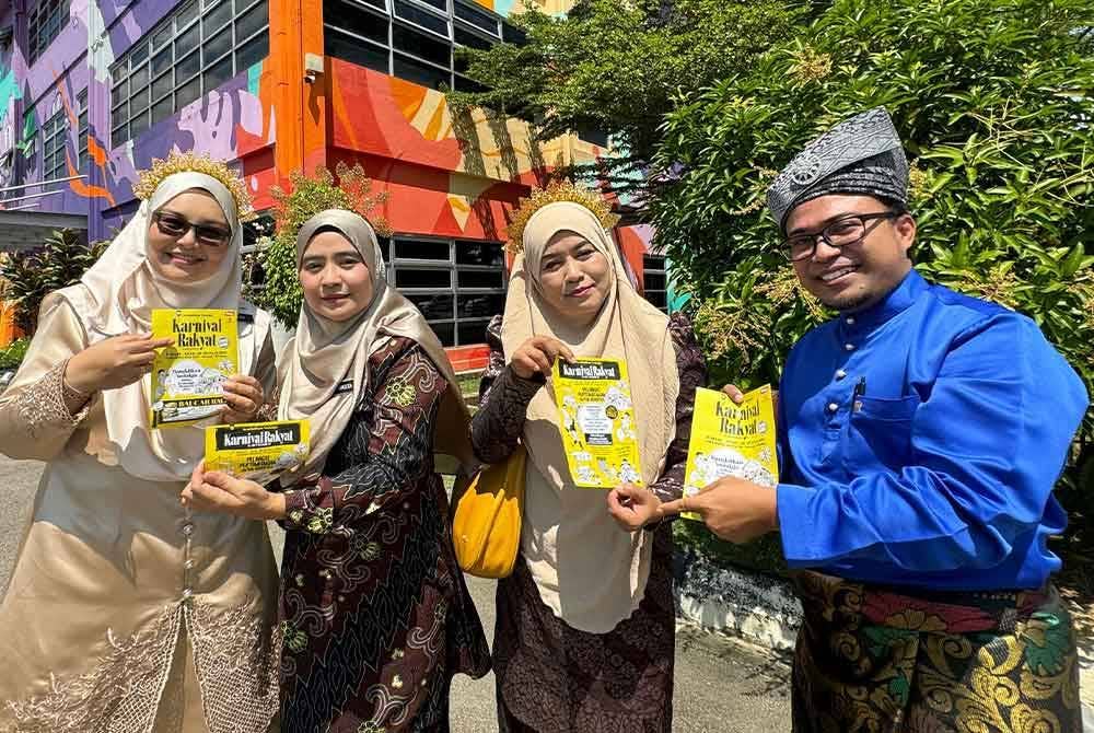 Masita (dua dari kiri) bersama pegawai JPNS menunjukkan poster Karnival Rakyat Karangkraf yang akan berlangsung di Kompleks Karangkraf, Shah Alam pada 26 hingga 28 Julai depan.