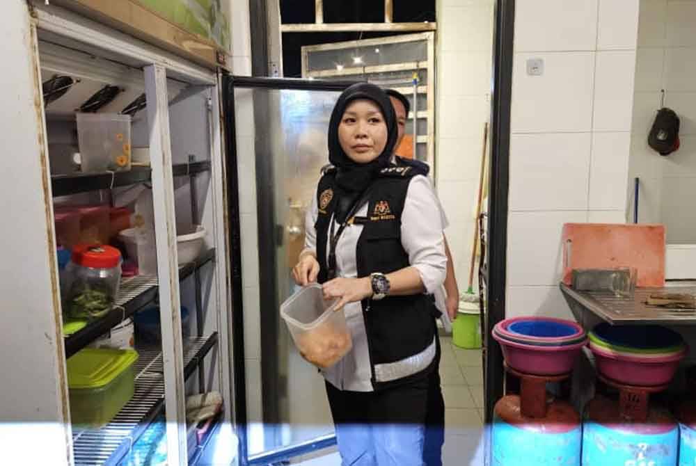 Penguat kuasa membuat teguran kepada pekerja premis berhubung kaedah penyimpanan makanan atau bahan mentah dalam peti sejuk ketika operasi dilaksanakan di Anjung Selera, Likas, Kota Kinabalu.
