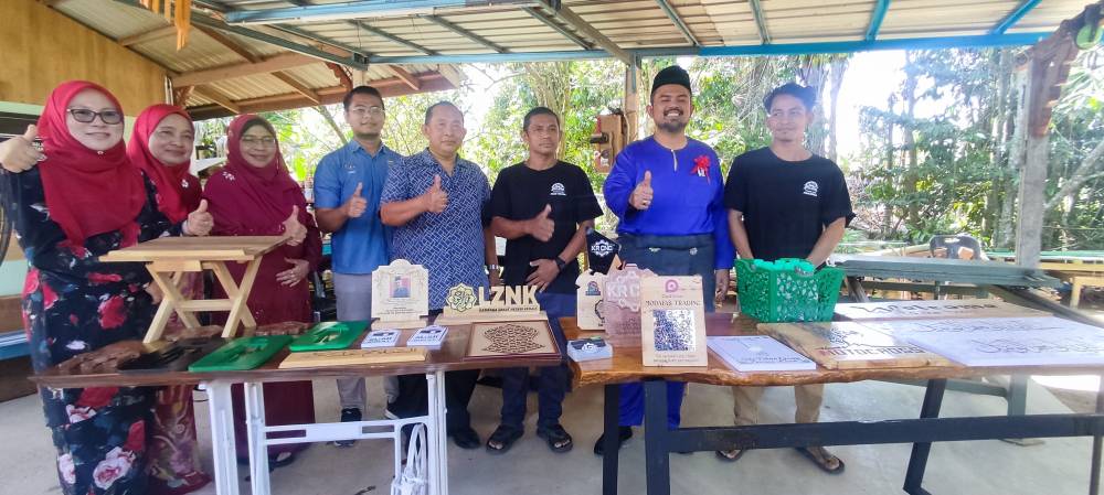 Manndzri (dua dari kanan) bergambar dengan barisan produk kraf tangan kayu yang dihasilkan Mohd Rizal (tiga dari kanan).