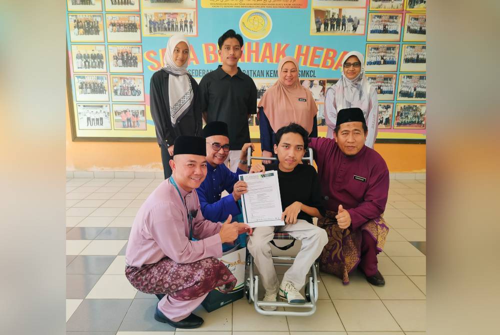 Dr Mohd Zawavi (duduk dua dari kiri) menyerahkan surat tawaran Program Asasi Kemanusiaan kepada Muhamad Adib Nadhir dalam satu majlis ringkas di SMK Chengal Lempong di sini pada Jumaat.
