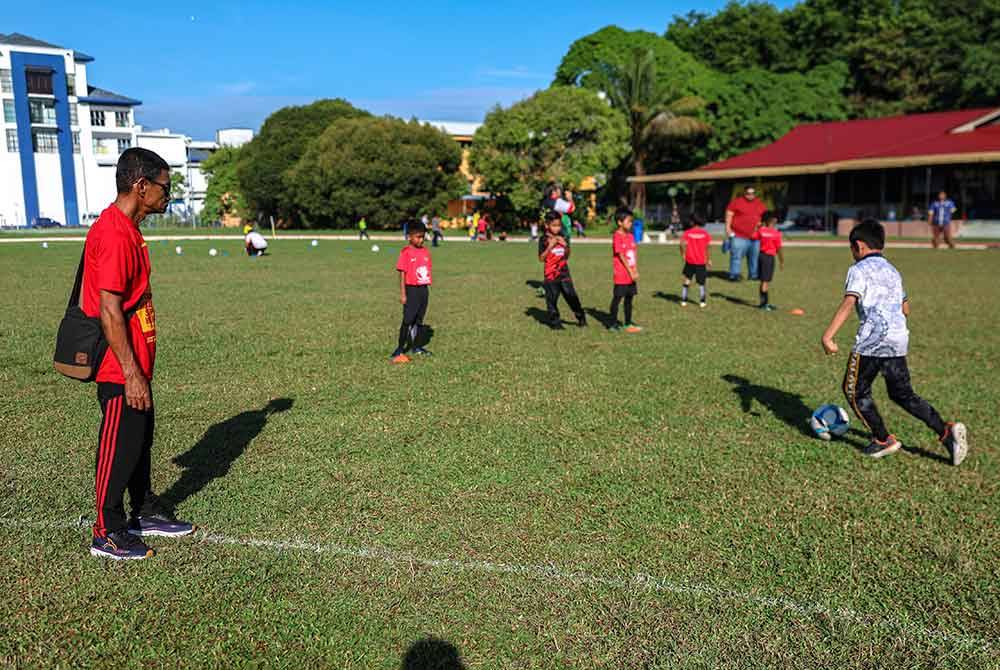 Bapa kepada Faisal Halim, Abdul Halim Saad melihat peserta bermain bola ketika hadir pada Klinik Bola Sepak MADANI anjuran Kelab Bola Sepak DNA Faisal Halim di Padang Awam Jawi hari ini.