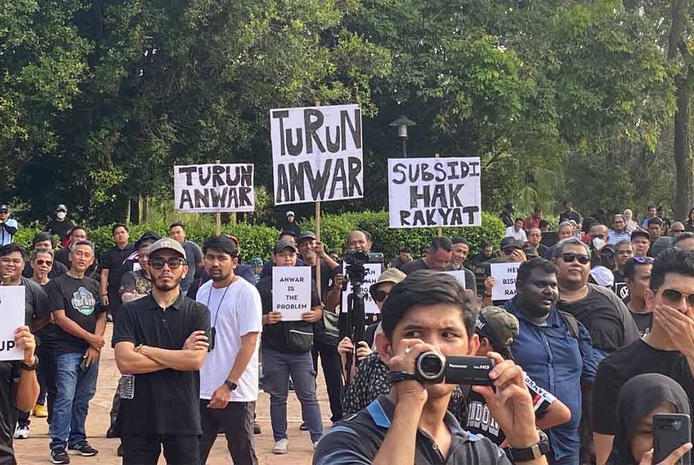 Kumpulan baju hitam berkumpul di tempat letak kenderaan di Kompleks Seri Perdana untuk menyertai perhimpunan 'Demo Rakyat Lawan Anwar' pada Sabtu.