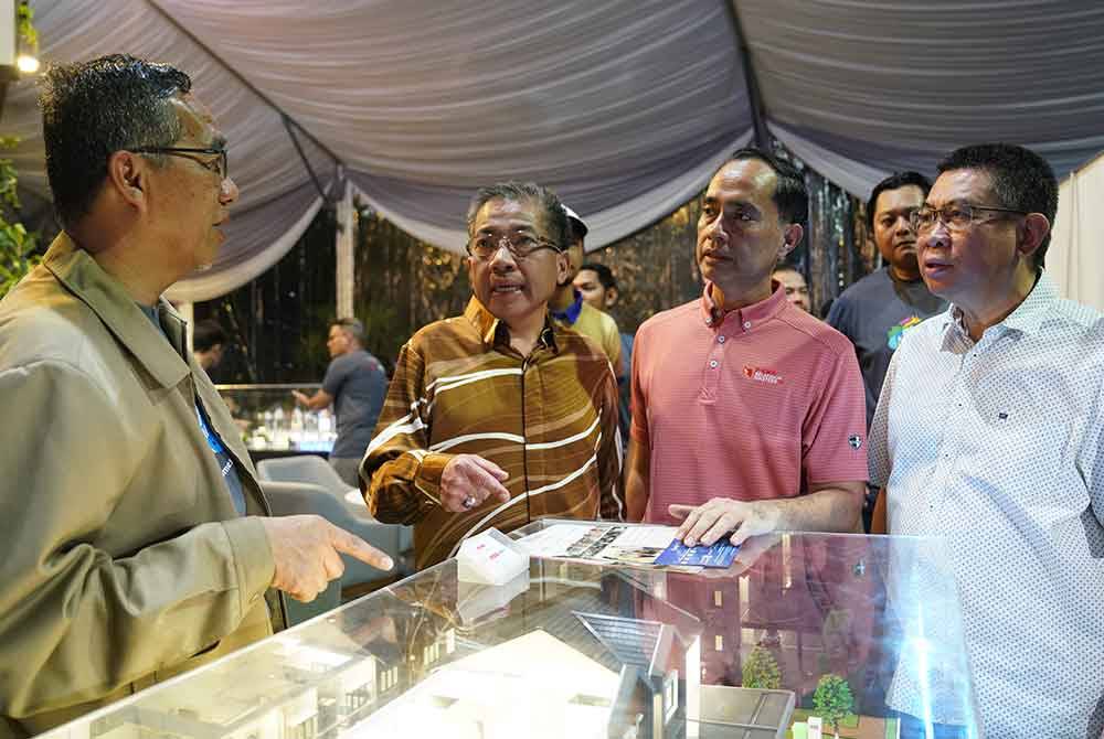 Md Kamarzan (dua dari kiri) menyaksikan produk hartanah PKNS yang dipamerkan di PKNS Pilih Karnival berlangsung di Dataran Kemerdekaan Shah Alam, pada Sabtu.