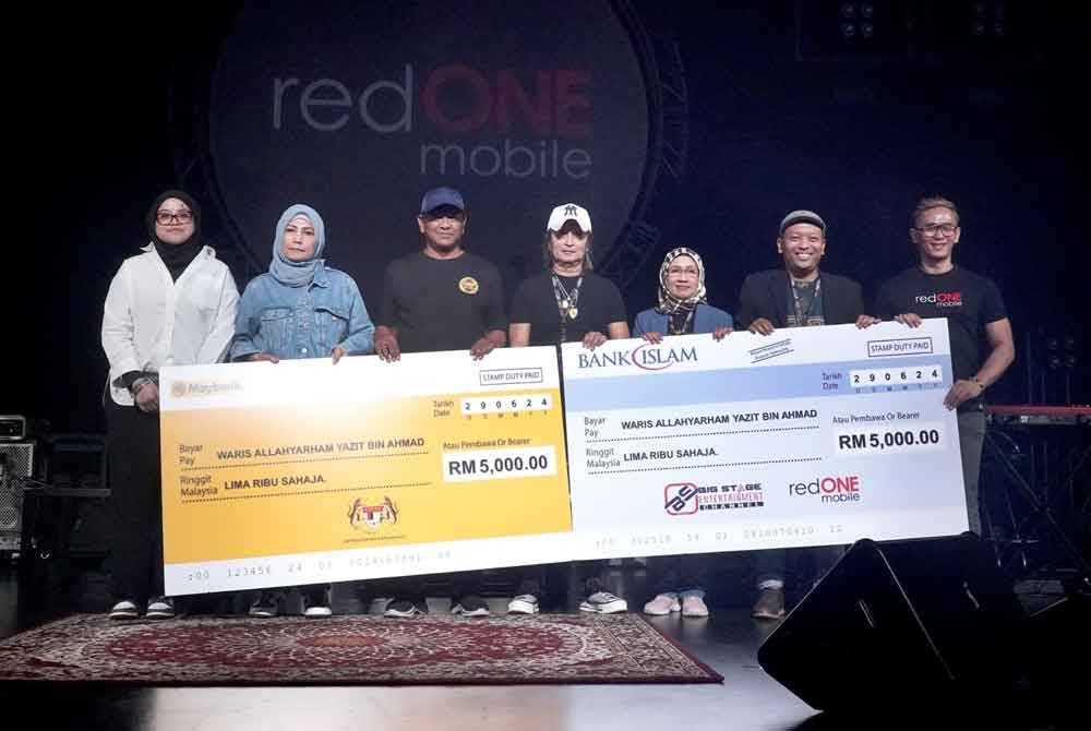 Izhar (tiga dari kiri) ketika menyampaikan sumbangan kepada keluarga Allahyarham Yazit di Konsert Search 'Gemuruh'.