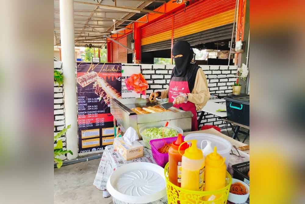 Farizah ketika menyiapkan tempahan roti john.