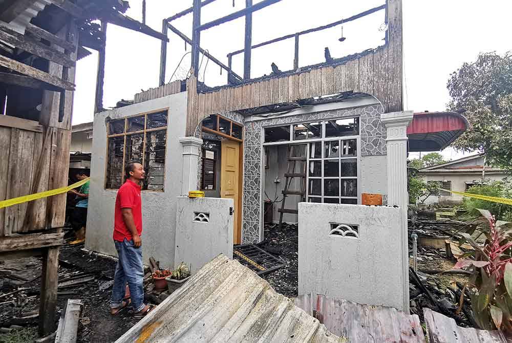 Roslan meninjau keadaan rumah keluarganya yang terbakar dalam kejadian di Kampung Gong Tok Nasek, di Kuala Terengganu pada petang Ahad.