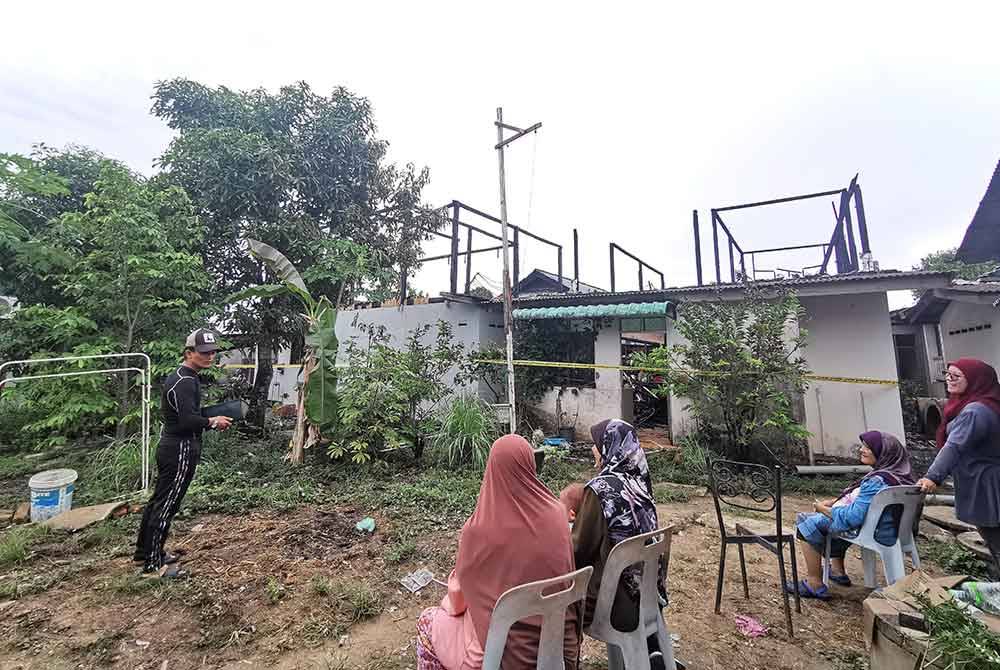 Mohd Abdul Salam (kiri) bersama jiran terdekat ketika ditemui penberita di lokasi kebakaran di Kampung Gong Tok Nasek di Kuala Terengganu.