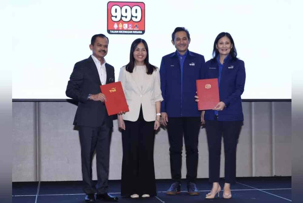 Nie Ching menyaksikan pertukaran dokumen antara Mohamad Fauzi (kiri) dan Shazurawati (kanan) pada majlis memeterai perjanjian untuk membangunkan dan mengendalikan sistem panggilan kecemasan baharu negara, Next Generation Emergency Services 999 (NG999) antara Kerajaan dan Telekom Malaysia (TM) pada Isnin. Foto Bernama