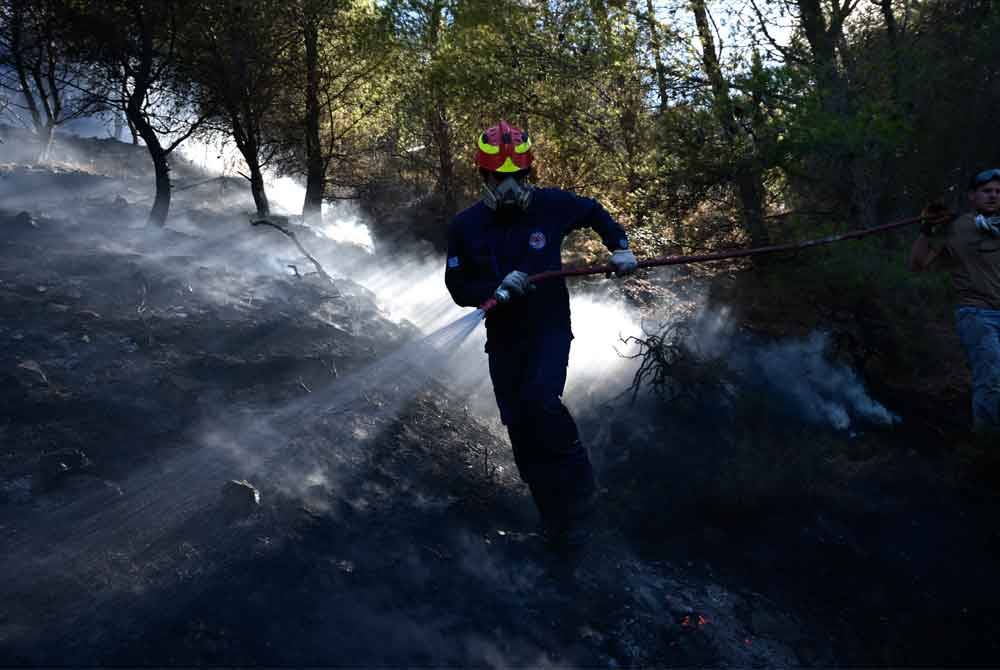 Anggota bomba bertungkus-lumus memadamkan kebakaran yang sukar dikawal akibat angin kencang berterusan sehingga 70 kilometer sejam di Keratea.
