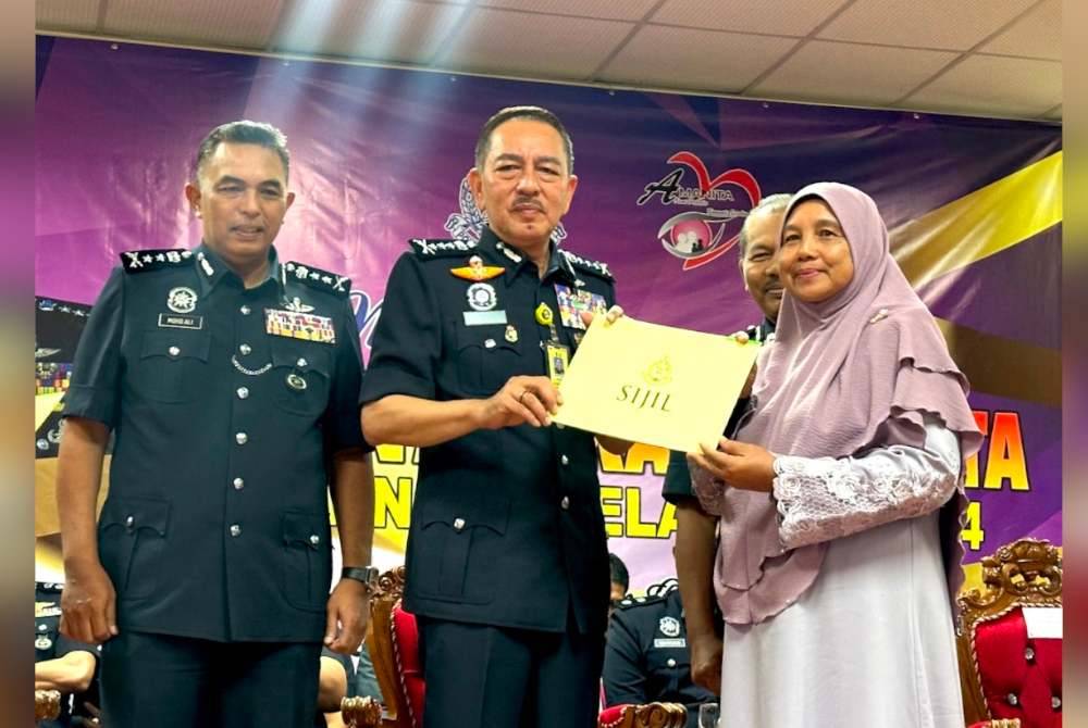 Muhamad Zaki (tengah) menyampaikan sijil Amanita kepada wakil komuniti di Machang.