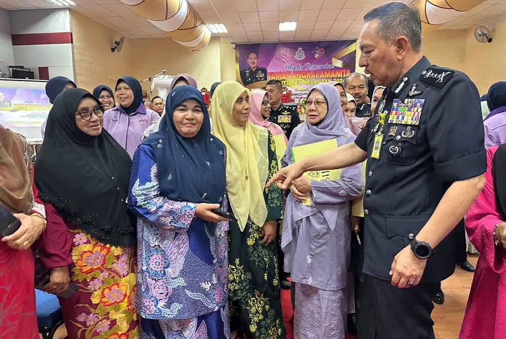 Muhamad Zaki (kanan) beramah mesra dengan komuniti yang hadir di Majlis Taman Angkat Skuad Aman Wanita (Amanita) Kontinjen Kelantan 2024.