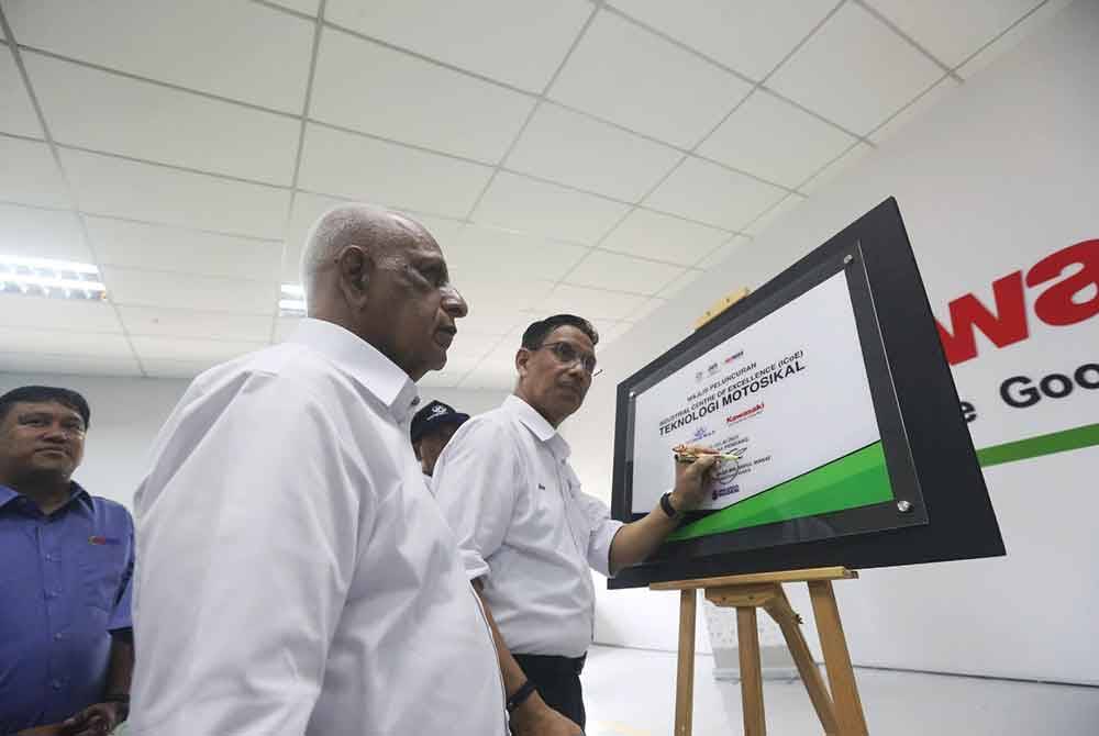 Azhar menandatangani plak perasmian Pusat Kecemerlangan Industri Teknologi Motosikal Modenas dan Kawasaki di GiatMara Pendang.