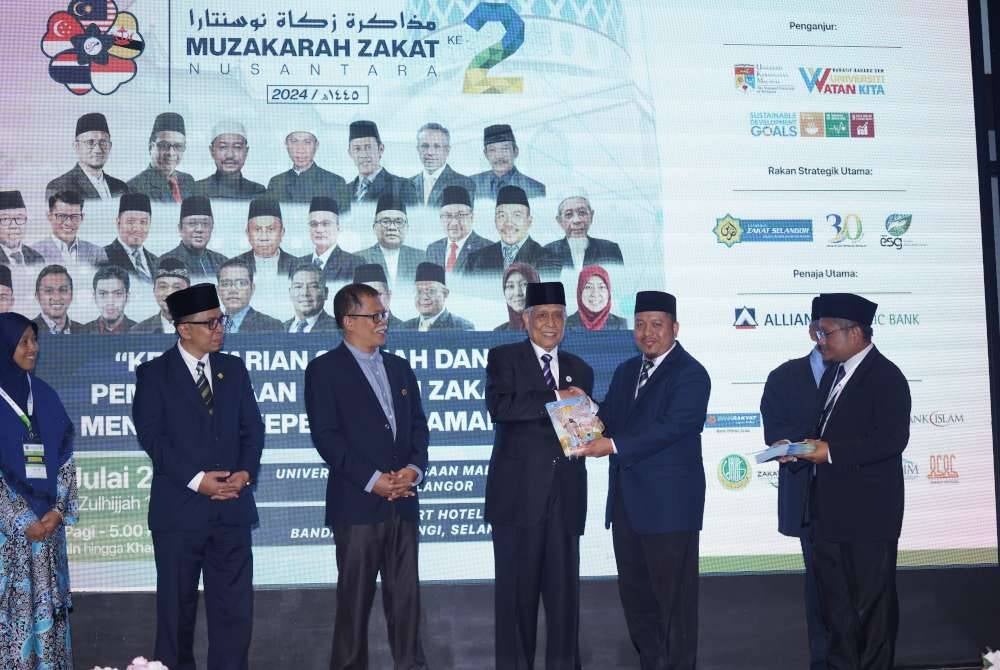 Abdul Aziz (tiga dari kanan) turut melancarkan Buku Karikatur Zakat.