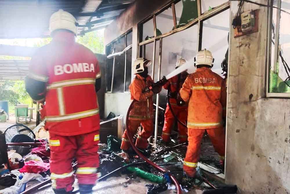 Anggota JBPM sedang melakukan kerja-kerja memadamkan kebakaran pada sebuah rumah di Kampung Chandan, Chetok di Pasir Mas pada Selasa.