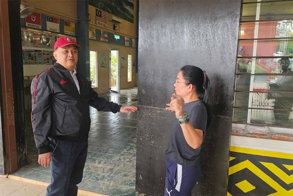Mohd Arifin (kiri) diberitahu paras air ketika banjir berlaku di St Michael, Penampang.