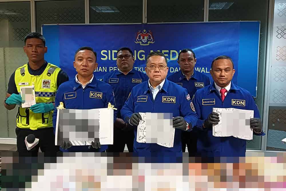 Nik Yusaimi (depan, dua dari kanan) menunjukkan bahan bacaan lucah yang dirampas KDN di seluruh negara menerusi Ops Cetak 1.0.