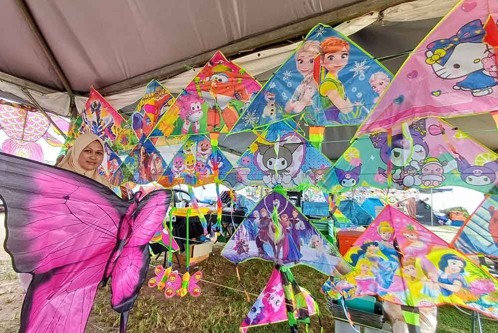 Norhaidah mempamerkan salah satu layang-layang besar berbentuk rama-rama yang dijualnya.