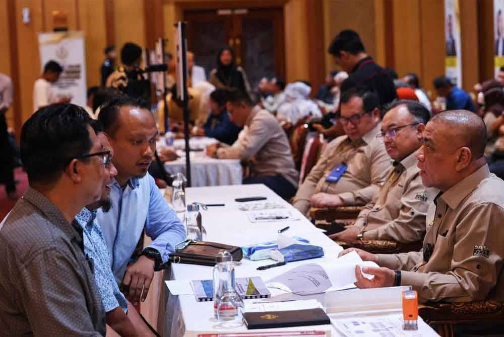 Saarani (kanan) menyantuni rakyat yang hadir sempena Program Mesra Hari Bertemu Pelanggan di Dewan Bankuet Bangunan Perak Darul Ridzuan di pada Rabu.