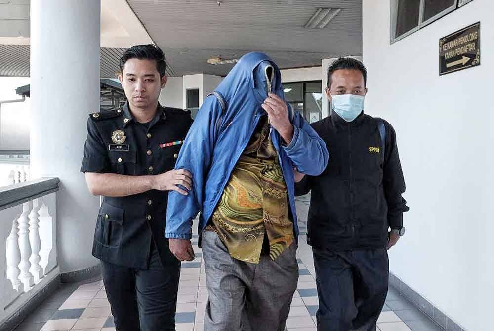 Selvarajah (tengah) dibawa keluar dari Mahkamah Sesyen di Melaka, pada Khamis.