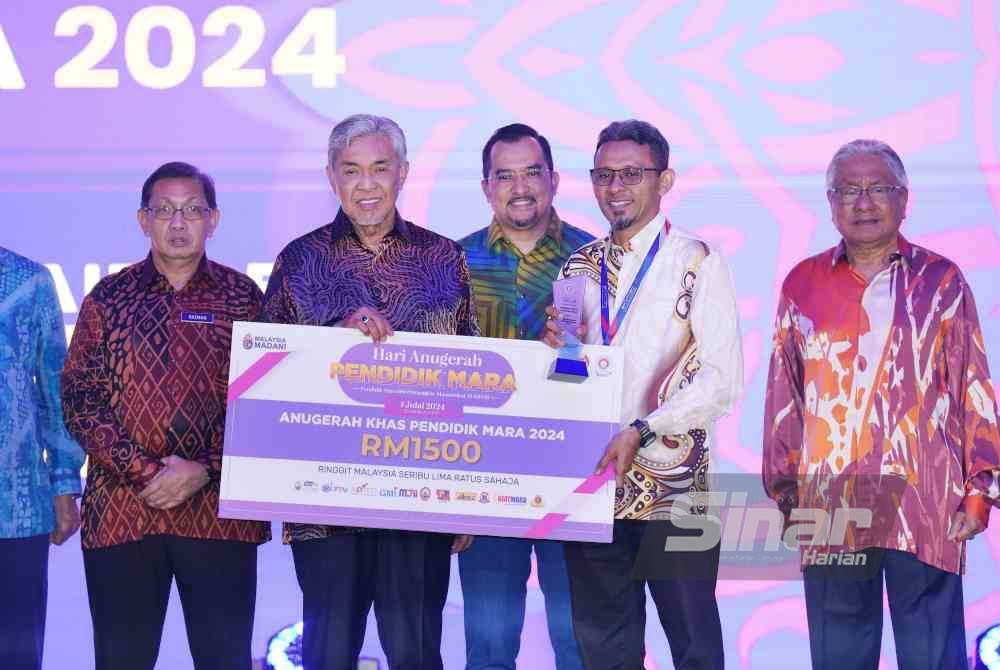 Timbalan Perdana Menteri, Datuk Seri Dr Ahmad Zahid Hamidi (empat dari kiri) menyampaikan Anugerah Khas Pendidik Mara kepada Mohd Khairis Harun pada Majlis Hari Anugerah Pendidikan Mara 2024 di sebuah hotel di sini pada Khamis. Foto Sinar Harian-MOHD HALIM ABDUL WAHID