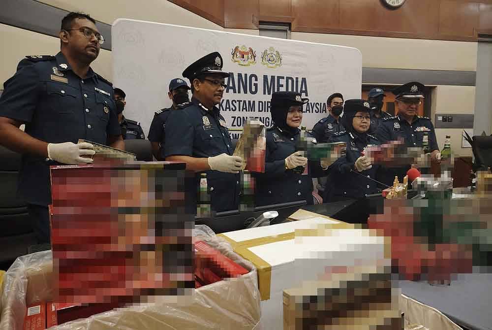 Norlela (empat dari kiri) menunjukkan rampasan rokok dan minuman keras yang dibuat JKDM di sekitar Lembah Klang, Jun lalu.