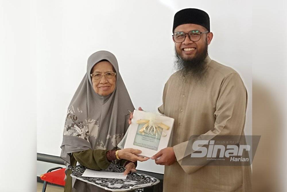 USTAZ AMIRO (kanan) menerima cenderahati daripada Pengerusi Persatuan Muballighat Negeri Selangor, Ustazah Masirah Maslan pada program Daurah Fiqh Muslimah Dalam Al-Quran Siri 1 di Shah Alam, Selangor baru-baru ini.