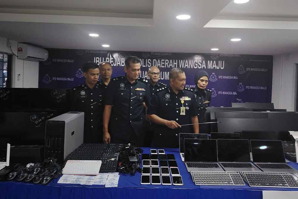 Mohamad Lazim (dua kanan) menunjukkan antara rampasan susulan tumpasnya sindiket judi dalam talian di ibu negara, 27 Jun lalu.