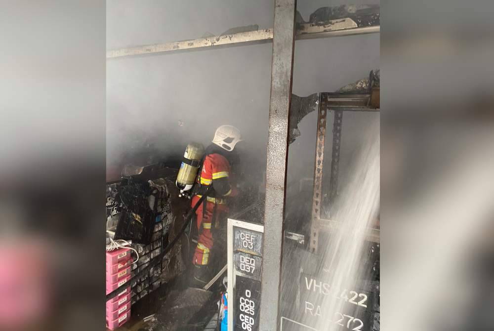 Anggota bomba membantu memadam kebakaran melibatkan kedai menjual plat kenderaan di Jalan Bukit Ubi di sini pada Jumaat.