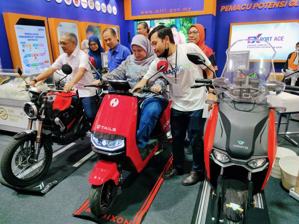 Rubiah mencuba motosikal yang dipamerkan.