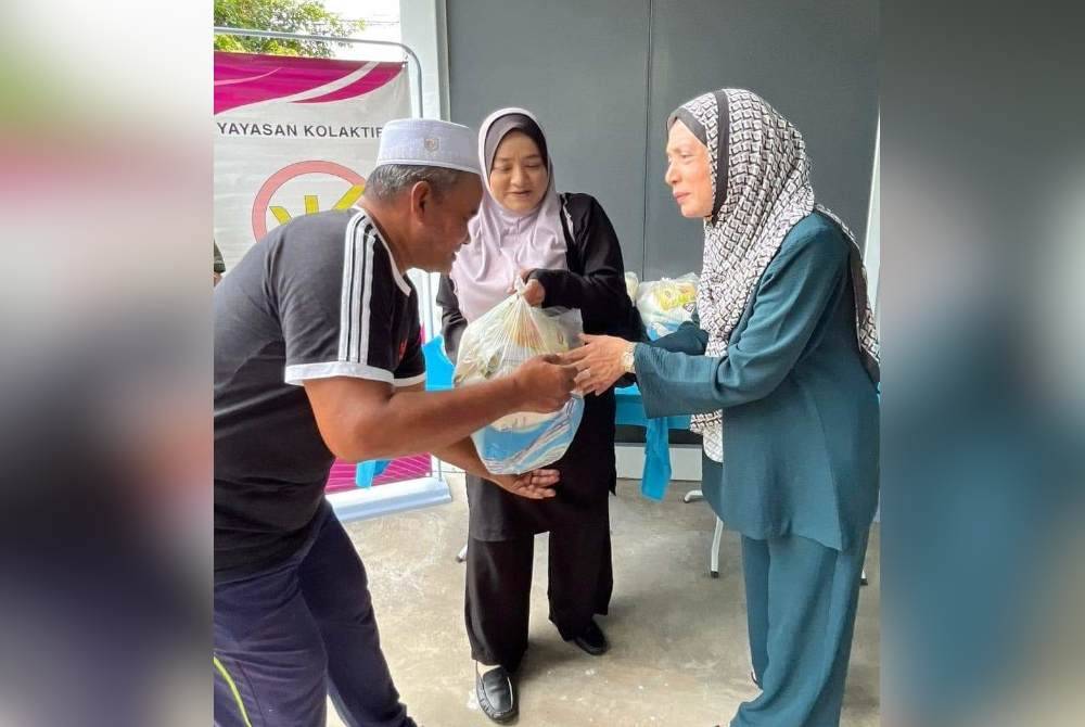 Dr Mashitah (kanan) menyerahkan sumbangan kepada penduduk di Kabin Mak Teh,di sini, baru-baru ini.