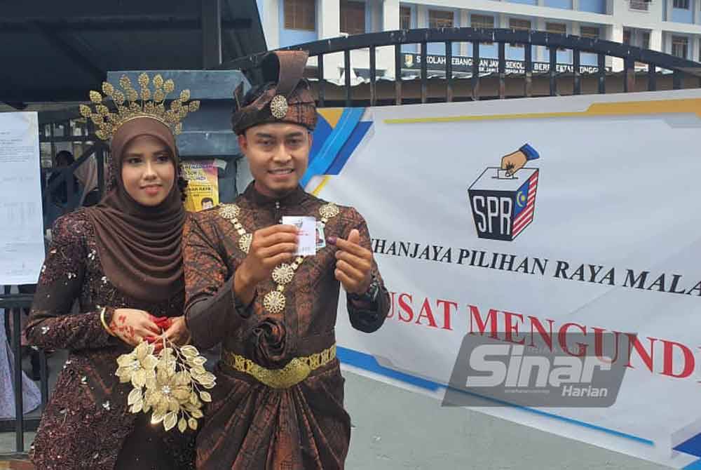 Muhammad Syafiq menunjukkan 'inai biru' selepas selesai mengundi di SK Jawi pada Sabtu.