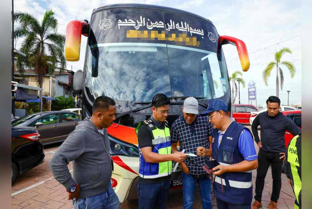 Mohd Zamri (dua dari kiri) memeriksa permit bas pada Operasi Khas Bersepadu Kenderaan Pelancongan dan Perkhidmatan Awam (Bas Persiaran dan Ekspres) di Pulau Warisan pada Sabtu.