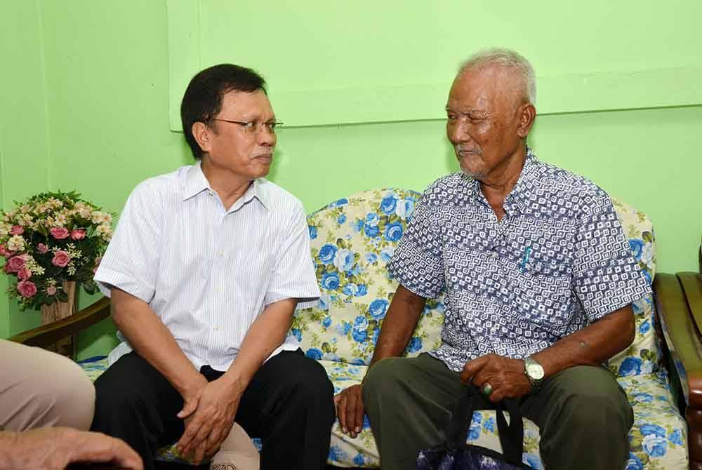 Mohd Shafie (kiri) ketika menziarah warga emas dalam program kasih Sembulan di Kampung Sembulan Tengah, Kota Kinabalu.