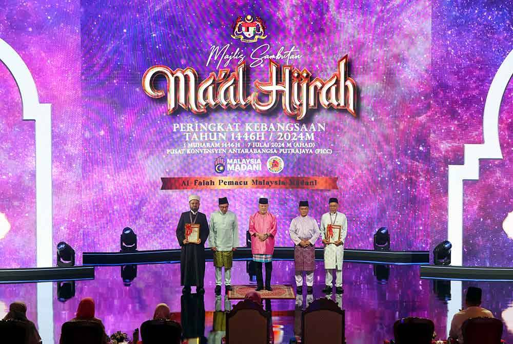 Yang di-Pertuan Agong Sultan Ibrahim (tengah) berkenan bergambar kenangan bersama kedua-dua penerima Anugerah Tokoh Ma'al Hijrah Tahun 1446H/2024M Kategori Antarabangsa Prof Dr Ali Muhyiddin Ali Al-Qaradaghi (kiri) dan Tokoh Ma'al Hijrah Tahun 1446H/2024M Kategori Kebangsaan Datuk Seri Hassan Ahmad (kanan).