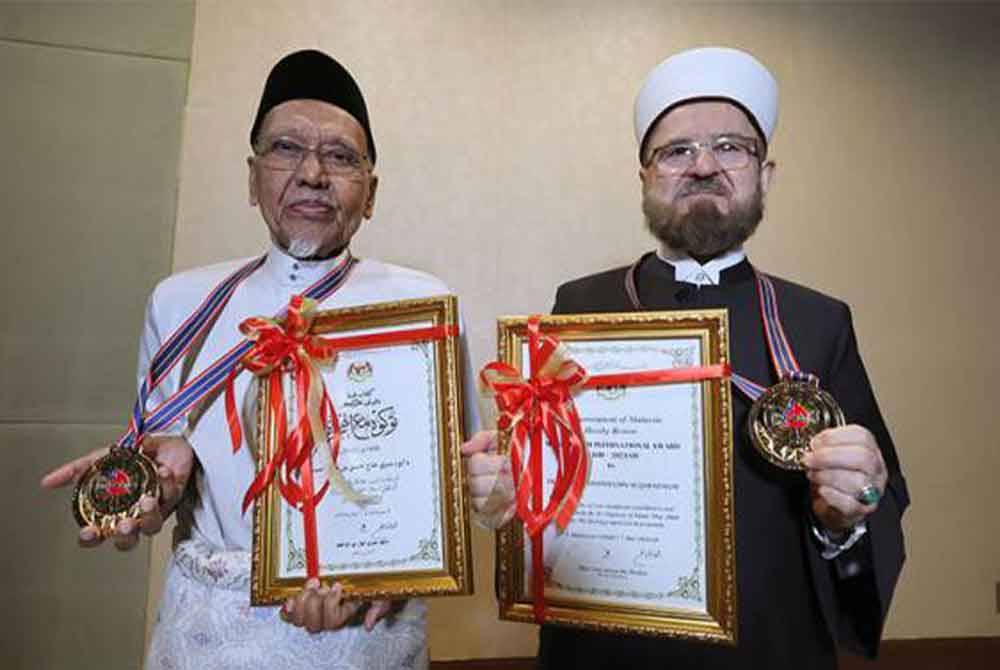 Penerima Anugerah Kategori Kebangsaan, Datuk Seri Hassan Ahmad (kiri) bergambar bersama penerima Anugerah Kategori Antarabangsa, Prof Dr Ali Muhyiddin Ali Al-Qaradaghi selepas Majlis Sambutan Ma'al Hijrah Peringkat Kebangsaan. - Foto Bernama