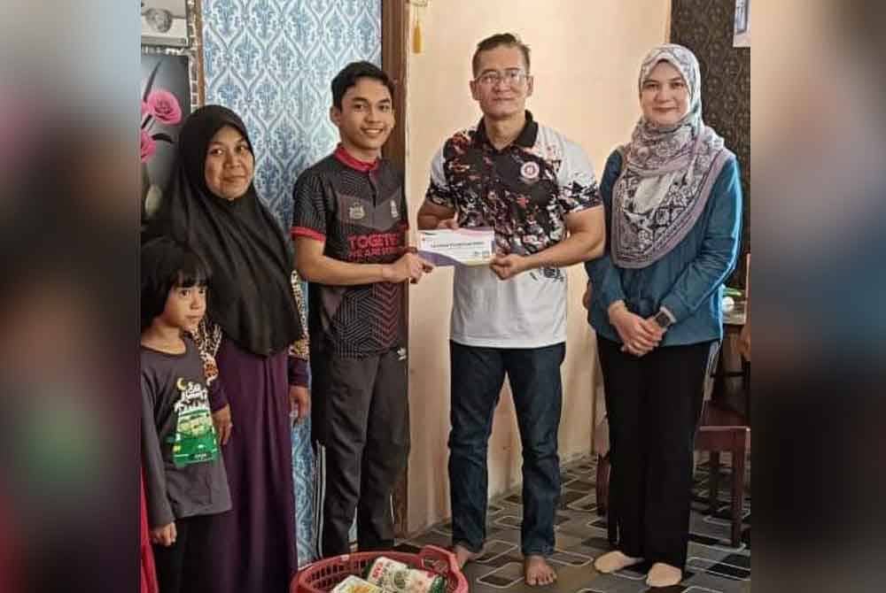 Allahyarham Rosdi (dua dari kanan) menyampaikan sumbangan Mara kepada pelajar cemerlang SPM kategori OKU di Gong Manak, Pasir Puteh pada Sabtu.