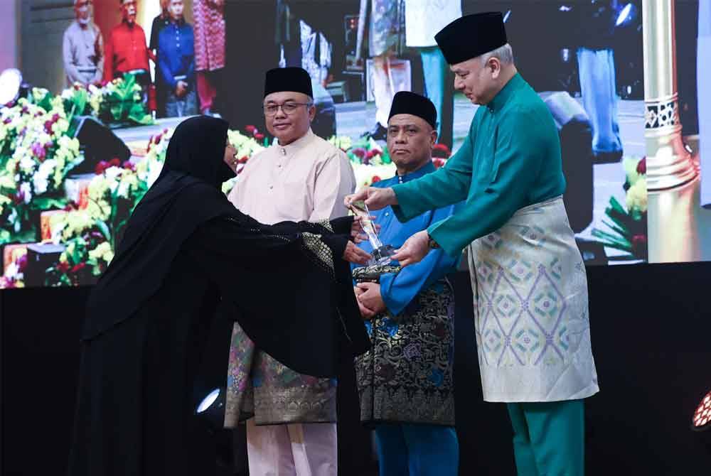 Sultan Nazrin menyampaikan Anugerah Siti Khadijah kepada Noor Mazlina Sempena Sambutan Kemuncak Maal Hijrah Negeri Perak Tahun 1446H di Pusat Konvensyen Casuarina pada Ahad.