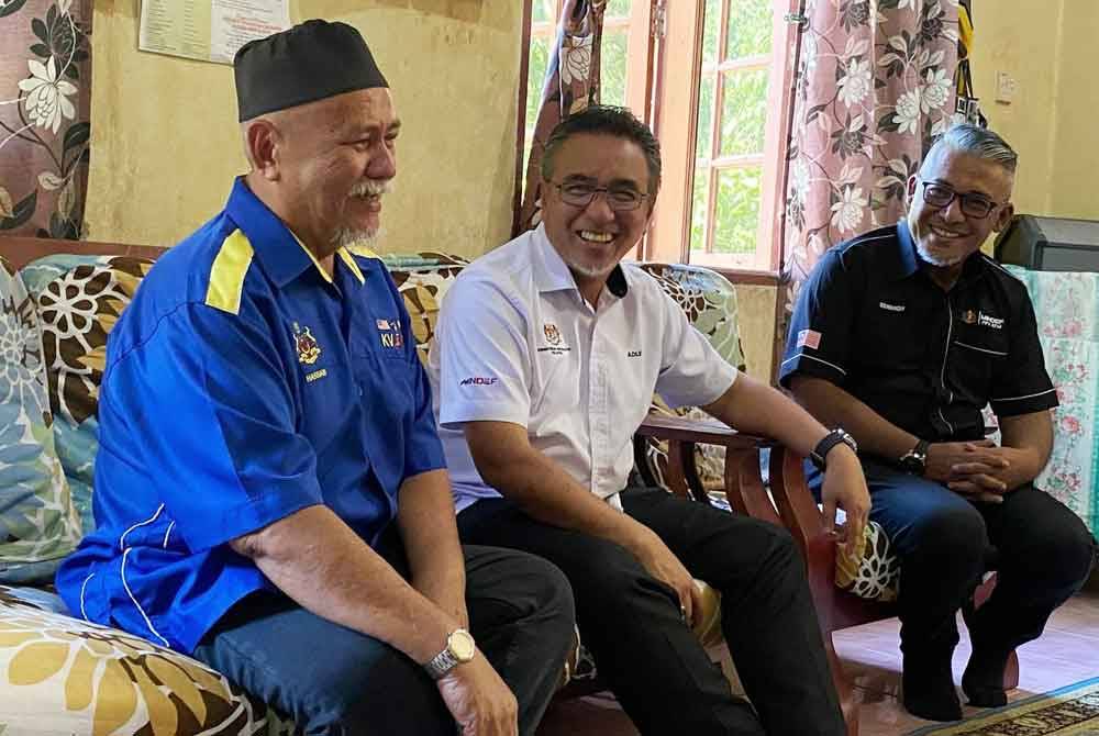 Adly (tengah) bertanyakan khabar pada Hassan semasa menyantuni veteran ATM pada Program Veteran Desa Madani di Kampung Chekok, Temangan, Machang pada Ahad.