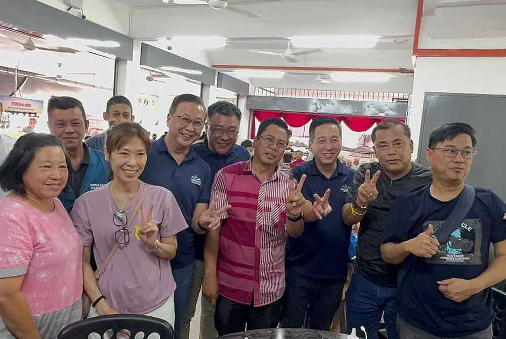 Abidin (empat dari kanan) bersama Dominic (enam dari kanan) dan pemimpin Parti Gerakan Pulau Pinang menyantuni penduduk Sungai Bakap di sebuah restoran pada Isnin.