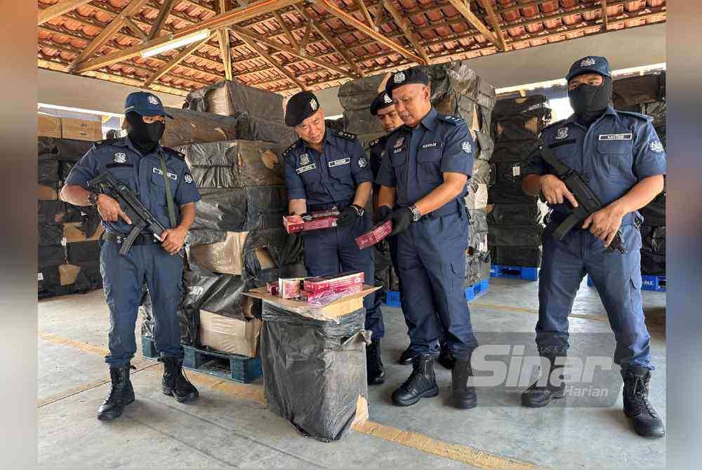 
Wan Jamal Abdul Salam (dua dari kiri) memeriksa rokok-rokok seludup yang ditemukan dalam kotak-kotak. Foto Sinar Harian/ADILA SHARINNI WAHID