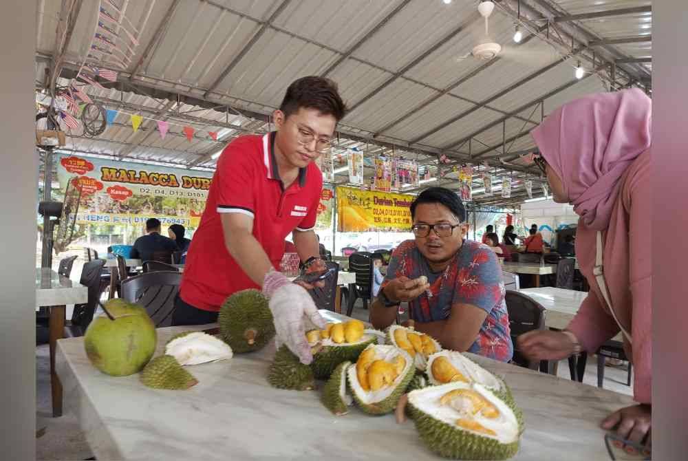 
Thian Yew(kiri) melayan pelanggan yang datang ke gerai jualannya di Bemban, Jasin ketika ditemui pada Isnin.