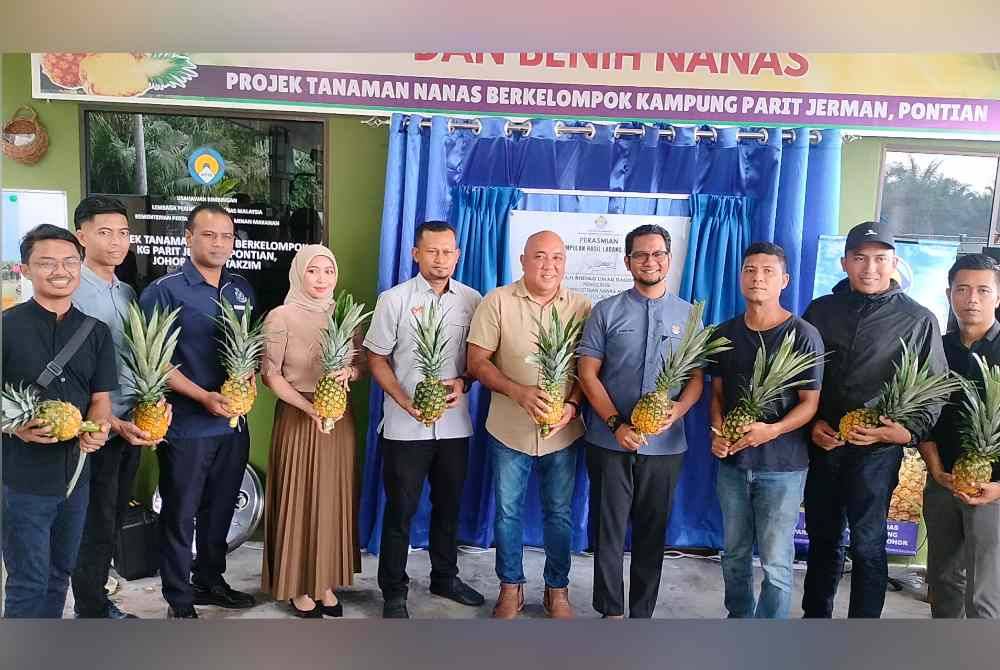 Sheikh Umar (empat dari kanan) bersama anak muda yang terlibat dalam Projek Taman Nanas Berkelompok di Kampung Parit Jerman Pontian, pada Isnin.