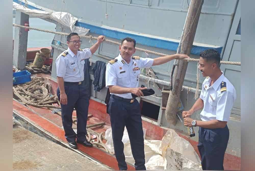 Khairulanuar (tengah) menujukkan bot yang dirampas.