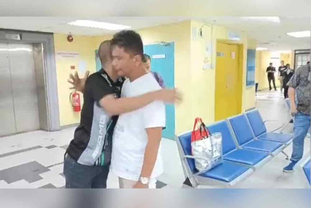 Mamat (kiri) memeluk abangnya, Mehmood selepas selesai pertuduhan kes memiliki dadah di Mahkamah Johor Bahru pada Isnin.