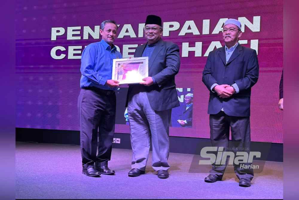 Mohamed Fadzli (dua dari kiri) menyampaikan penghargaan kepada pembentang Simposium Mineral Strategik Unsur Nadir Bumi Kelantan 2024.
