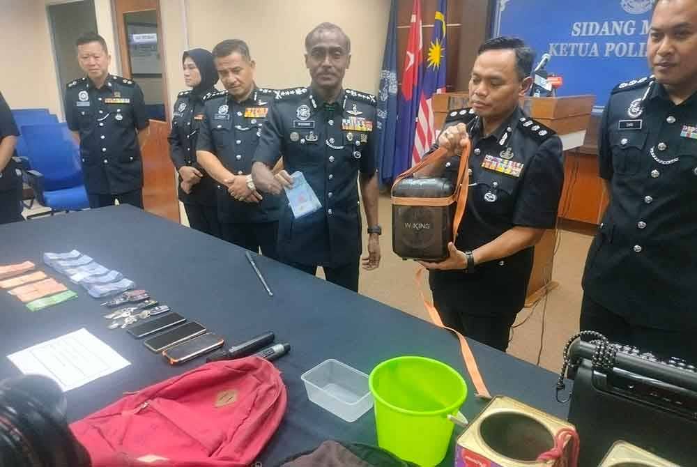 Kumar (tiga dari kanan) dan Raub (dua dari kanan) menunjukkan wang dan pembesar suara yang digunakan OKU warga asing yang diekspoitasi sindiket menjadi pengemis di bandar raya ini.